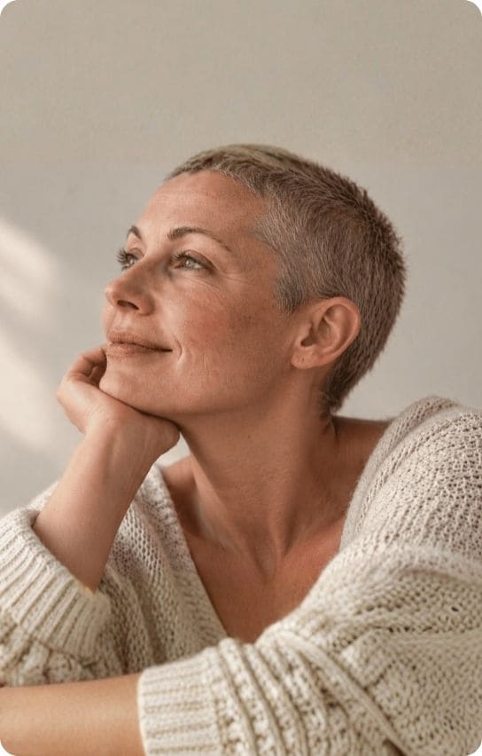 Femme aux cheveux courts en repousse après un traitement, prenant soin de son cuir chevelu